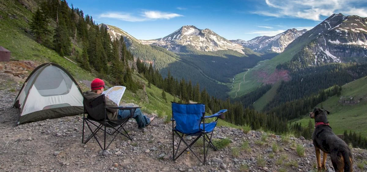 camper sitting in a chair overlooking a beautiful valley scene | Telluride