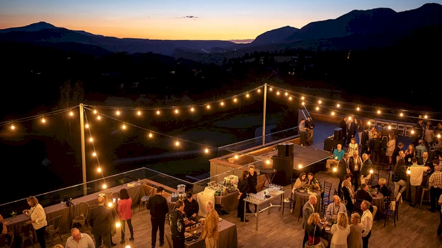 image of a large gather at dusk with lights, tables and food. | Telluride Reserve